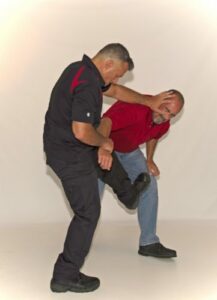 Self defense trainer showing how to defend in bottom